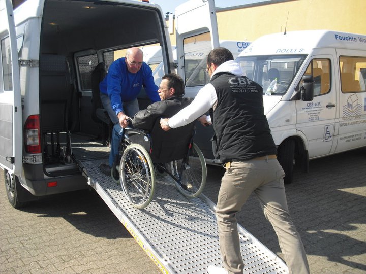 Fahrpersonal lädt Rollstuhlfaher in Bus ein
